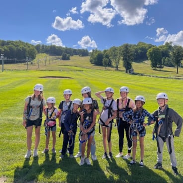 Kids in zipline gear posing for a photo at The Highlands