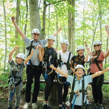 Family posing in zipline gear at The Highlands