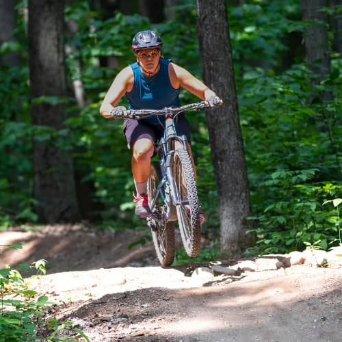 Woman on bike with wheels up at The Highlands Bike Park