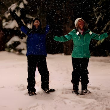 Couple posing on night snowshoe hike to North Peak at The Highlands