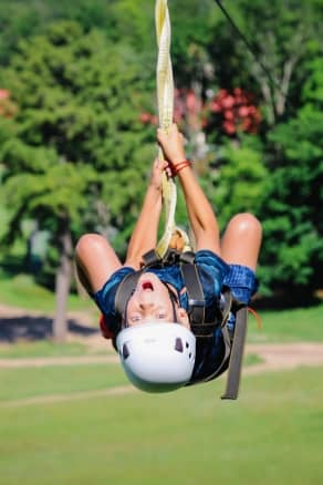 A child on a zipline adventure during the summer at The Highlands