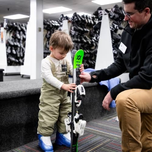 A small child getting sized for rental gear at The Highlands