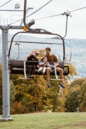 Family Smiling on Scenic Chairlift Ride in Fall at The Highlands