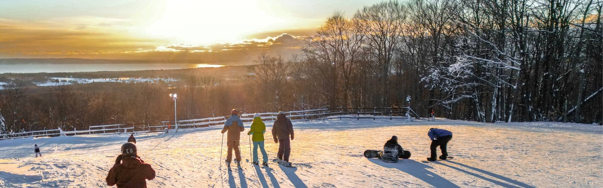 Skiers viewing the overlook at sunset at The Highlands